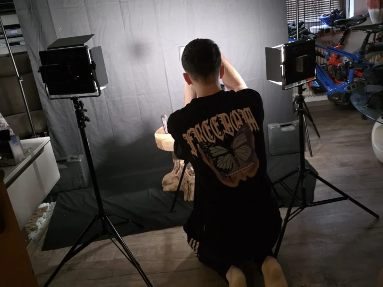 Fotograf kniet vor einem beleuchteten Set für Produktaufnahmen