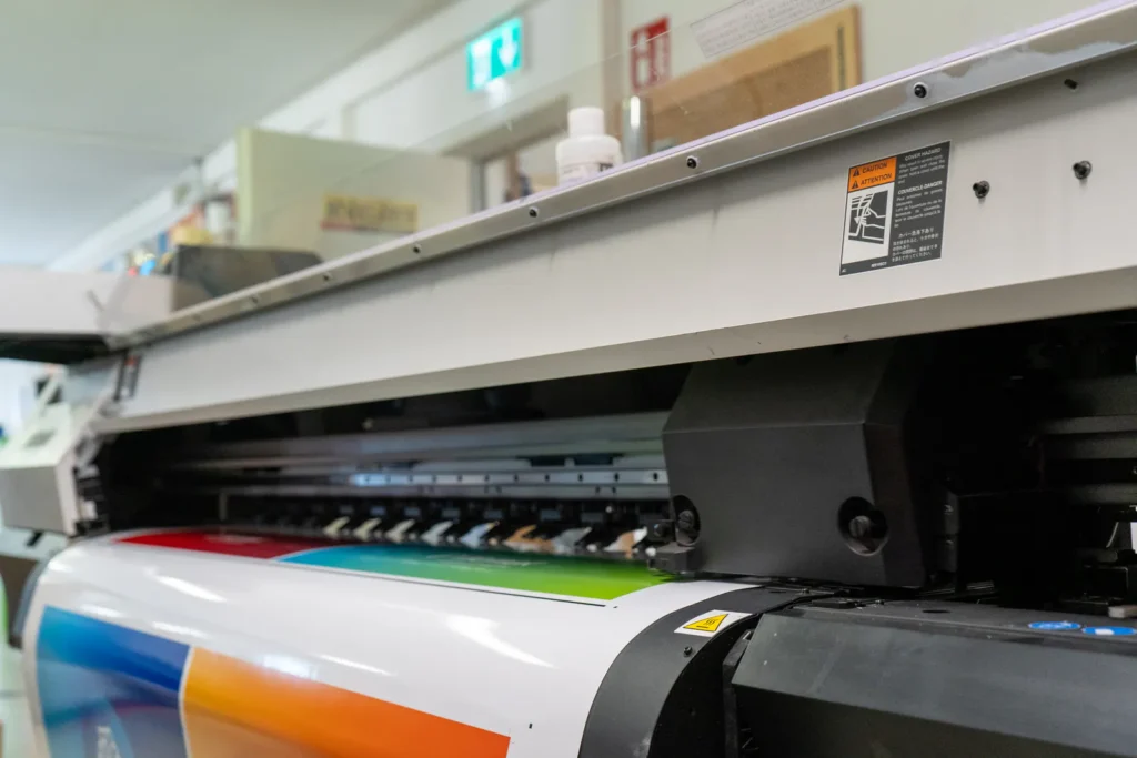Großformatdrucker druckt eine farbige Bahn