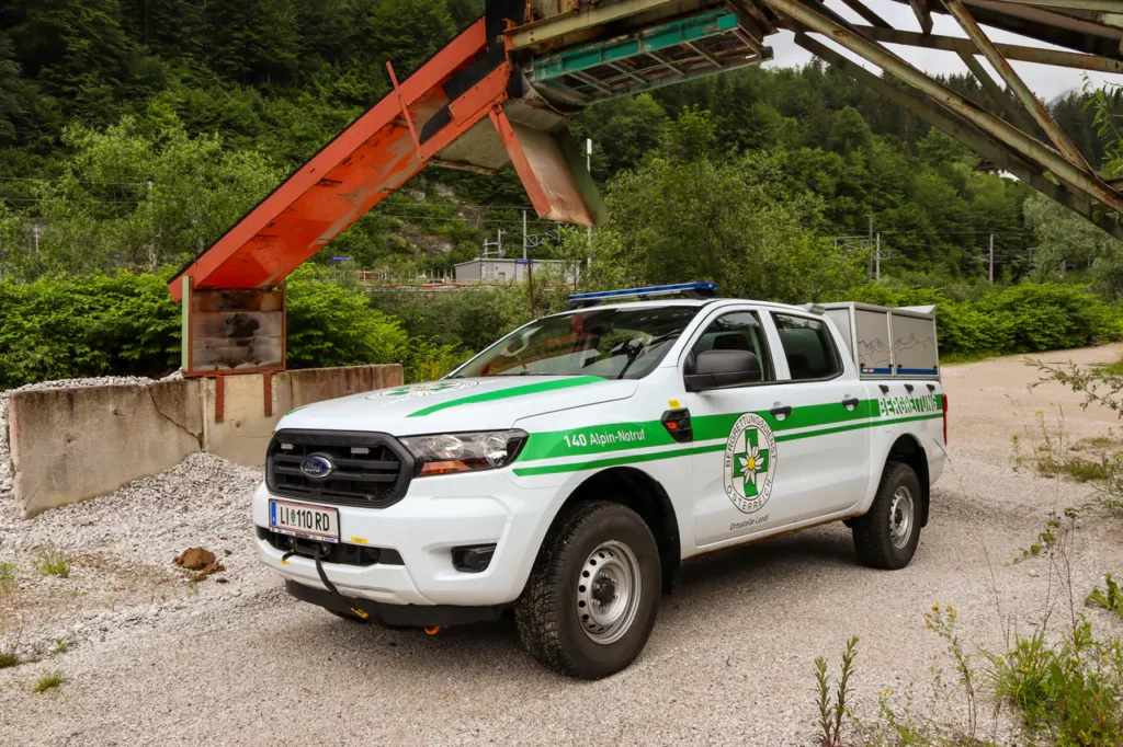 Weißer Pick-up mit grüner Beschriftung der Bergrettung im Gelände