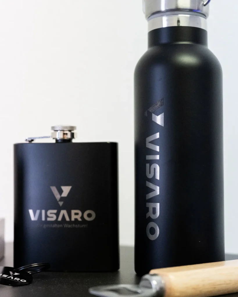 Schwarze Trinkflasche und Flachmann mit VISARO Gravur